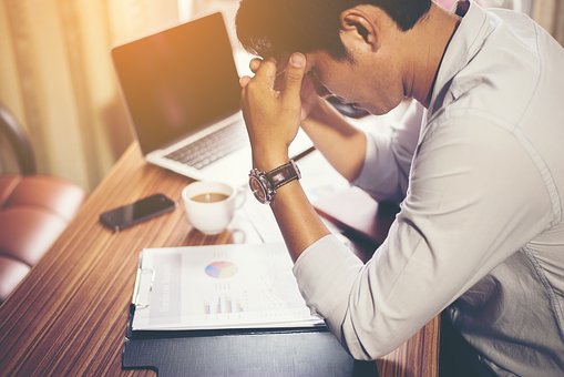 Man looking stressed in a cubicle.